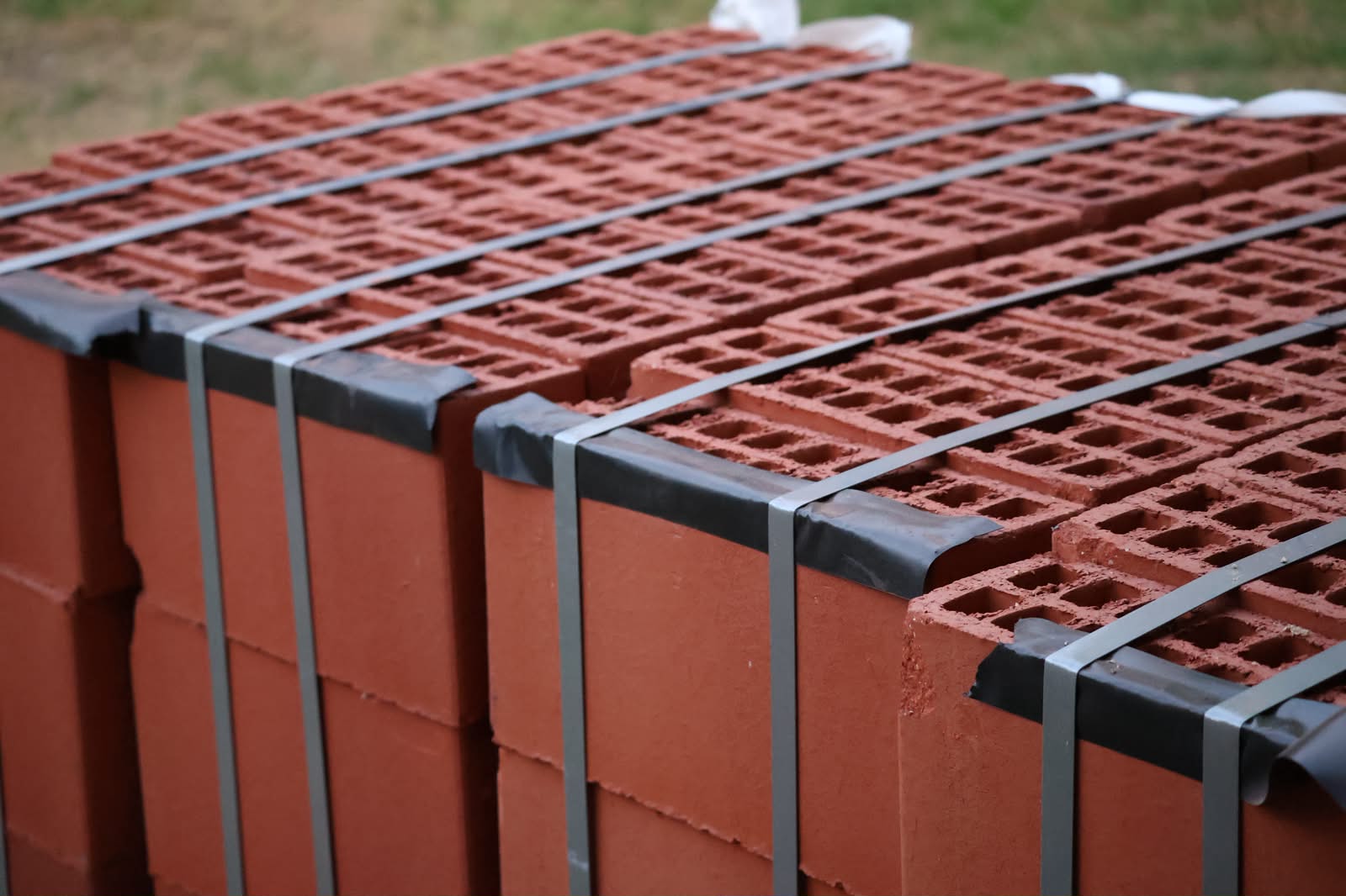 Banded packs of red two-course bricks on a building site