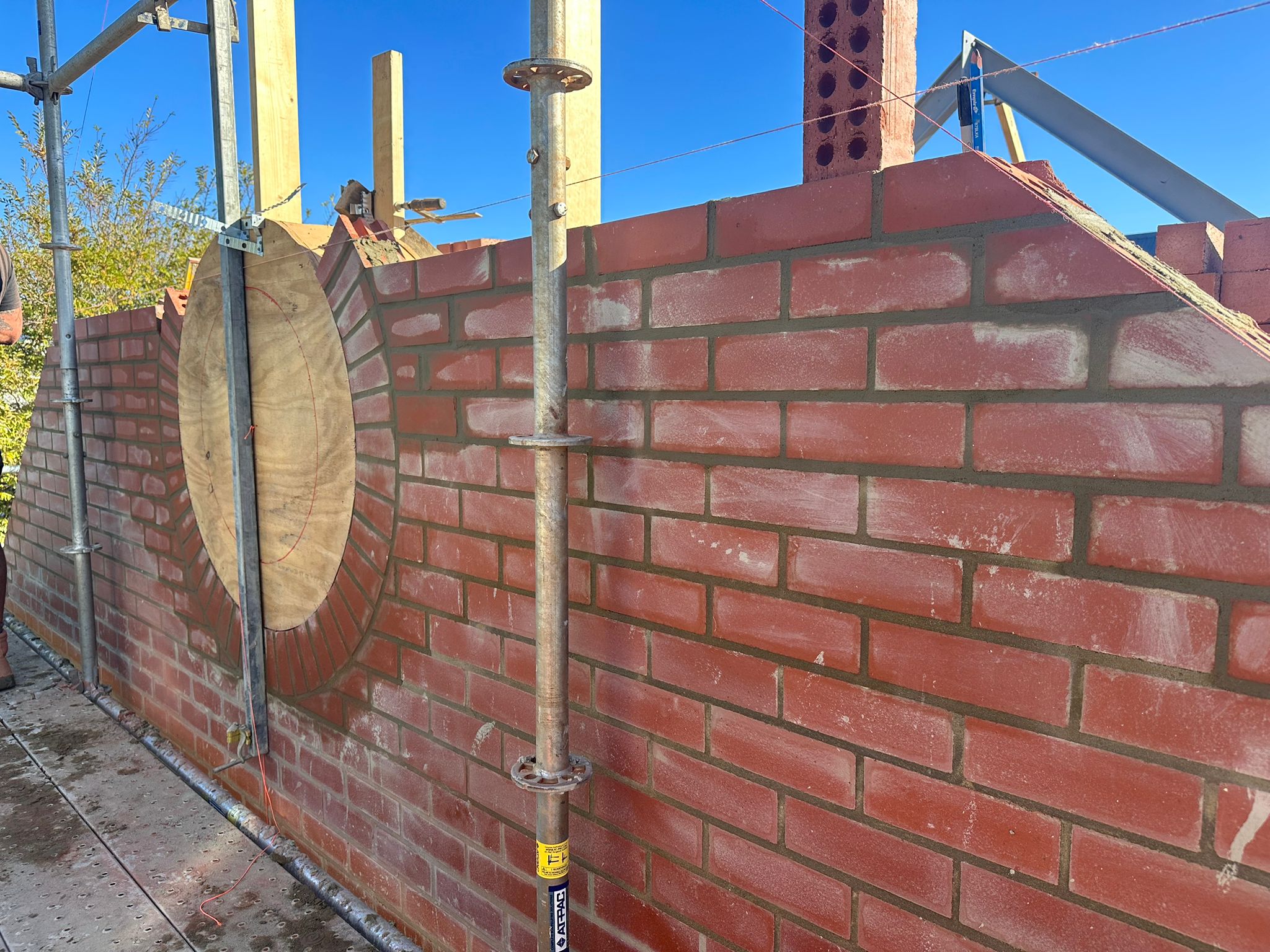 Custom circular window design — first brick courses set out, Cottesloe